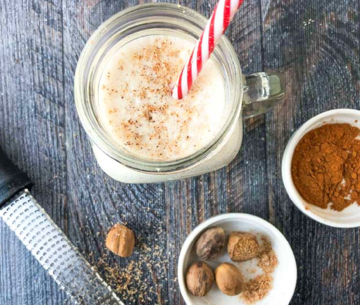 Aerial view of the protein drink and fresh nutmeg and ground cinnamon and a microplane.