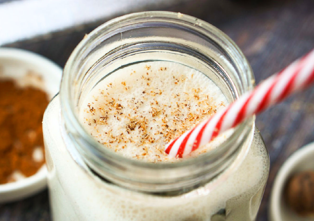 Closeup of the finished drink with the sprinkled nutmeg on top and red striped straw.