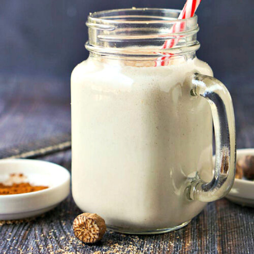 A glass jar with a serving of low carb eggnog protein shake.
