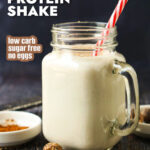 A glass jar with a serving of low carb eggnog protein shake and text overlay.