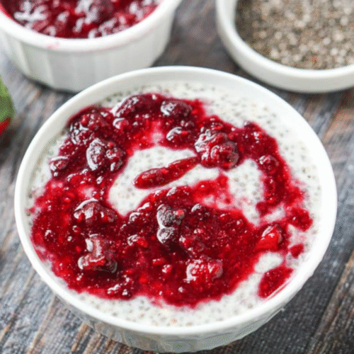 Closeup of berry chia protein pudding in a white bowl.