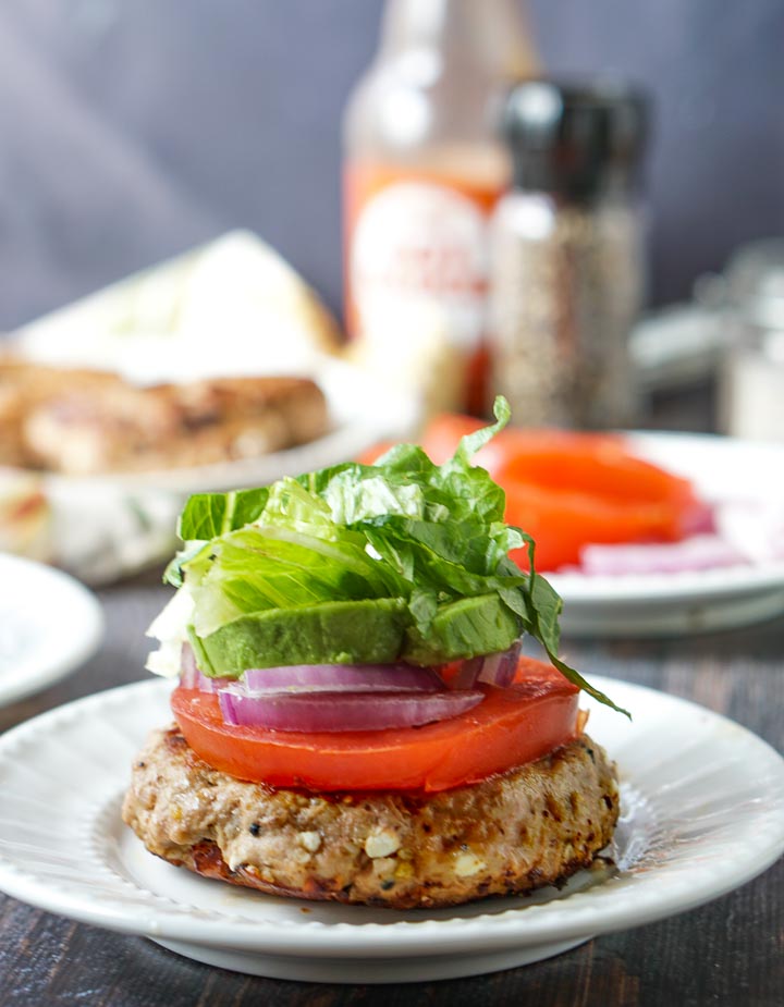 low carb turkey burger with a slice of tomato, red onion, avocado and lettuce on top 