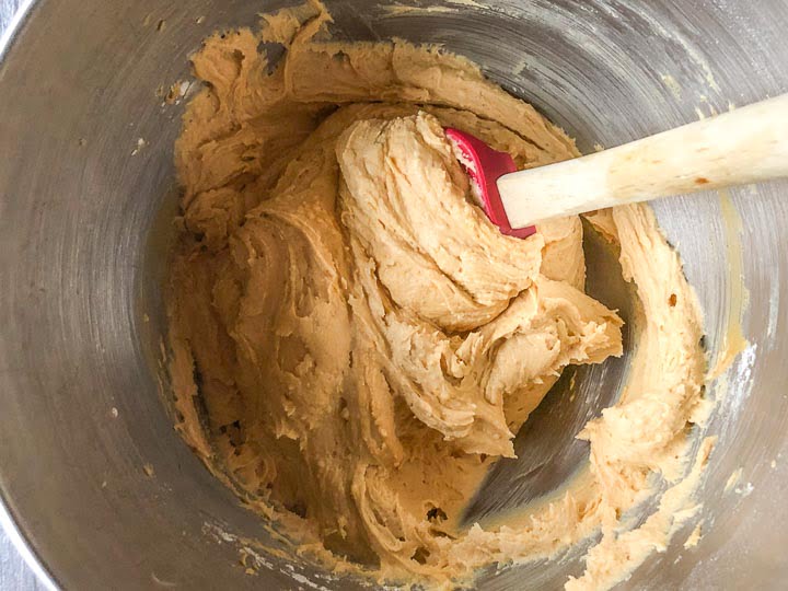 a mixing bowl with sugar free peanut butter fudge batter and a spatula 
