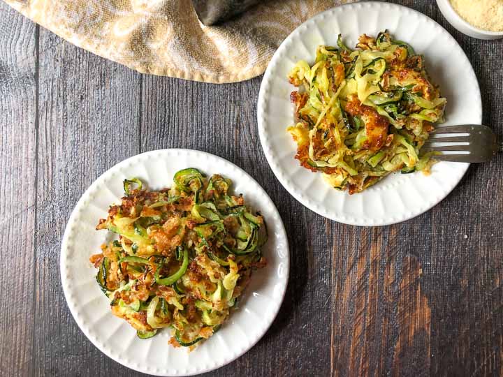 two white plates with air fryer baked zucchini noodles