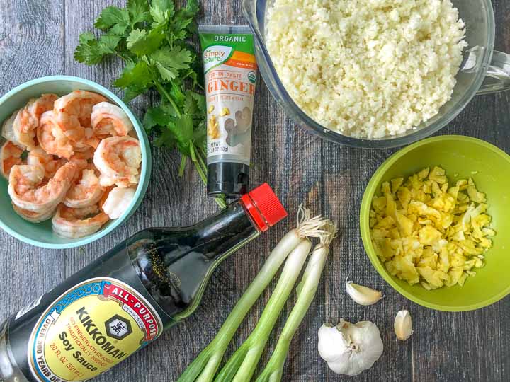 ingredients for keto fried cauliflower rice: shrimp, cauliflower rice, ginger, cilantro, green onions, garlic, soy sauce and scrambled egg