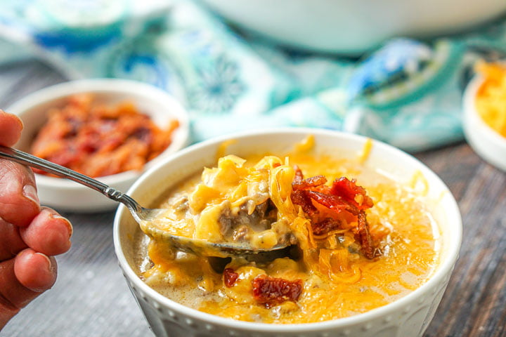 spoonful of the keto cheeseburger soup with the bacon in the background