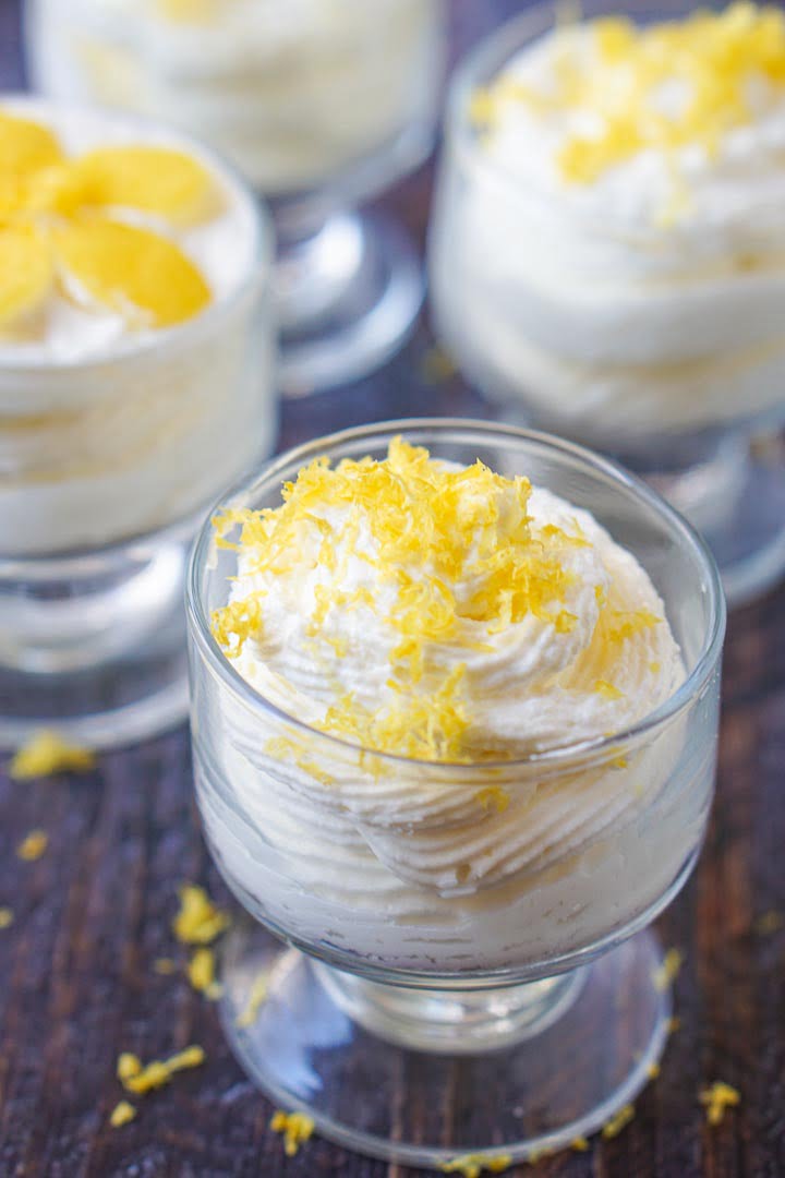 closeup of a couple glass cups with keto cheesecake mousse with lemon zest on top