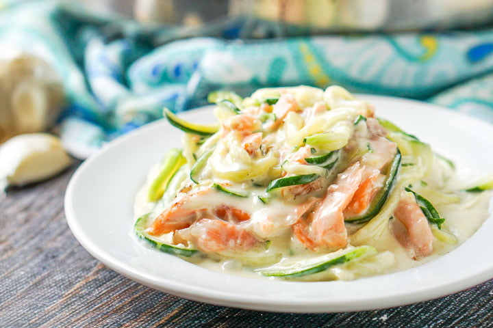 closeup of white plate of low carb Alfredo salmon and zucchini noodles