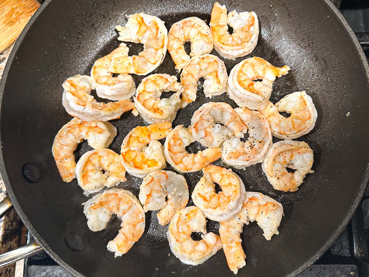 Skillet with cooked shrimp.