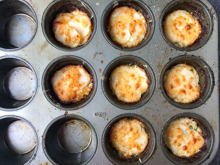 muffin tin of baked mini keto scalloped turnips all brown and cheesy on top