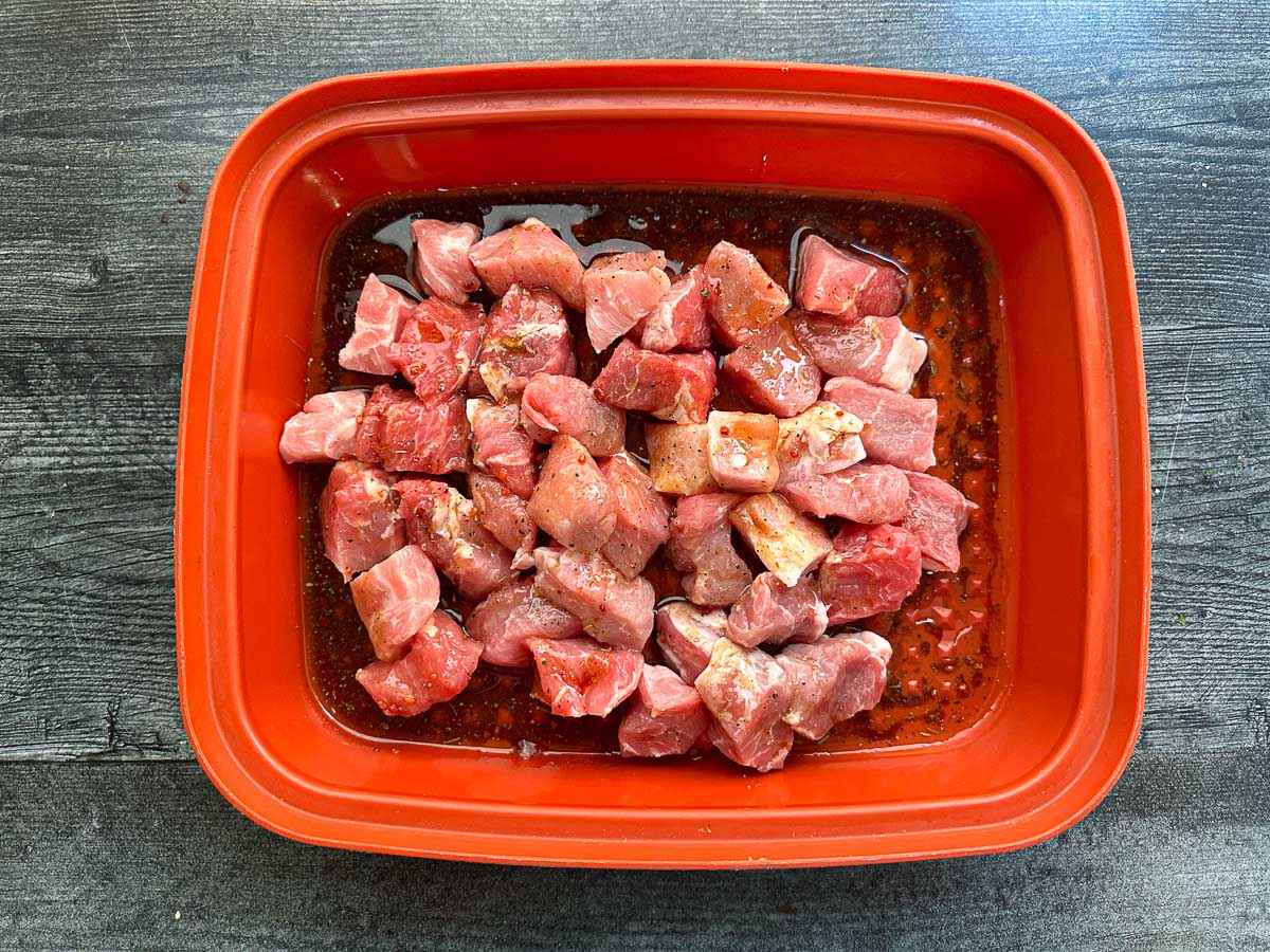 marinating container with pork pieces with marinade