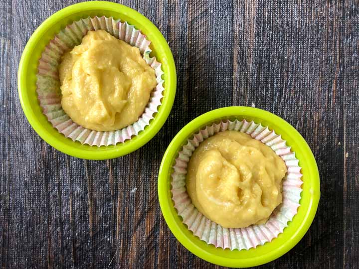 two green ramekins with paper cupcake liners and the sugar free cupcake batter