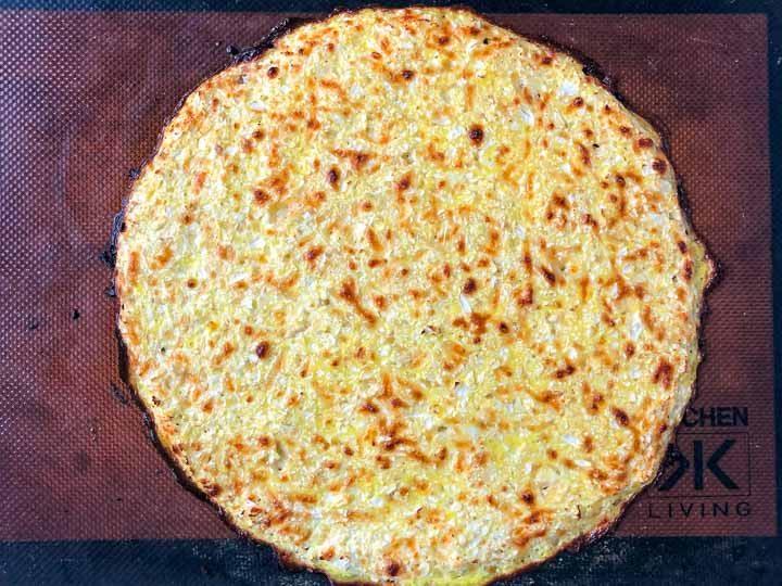 A cooked cauliflower crust for chicken alfredo pizza