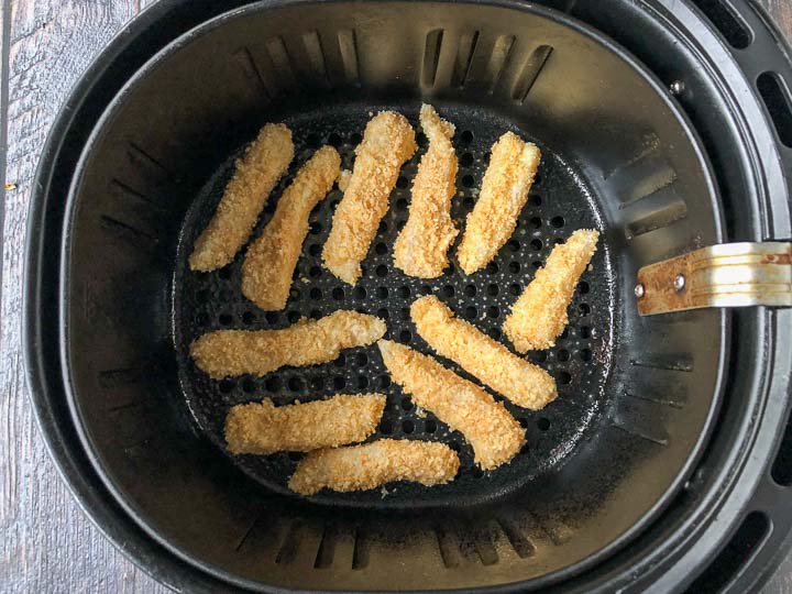 keto fish sticks in the basket of an air fryer ready to be baked