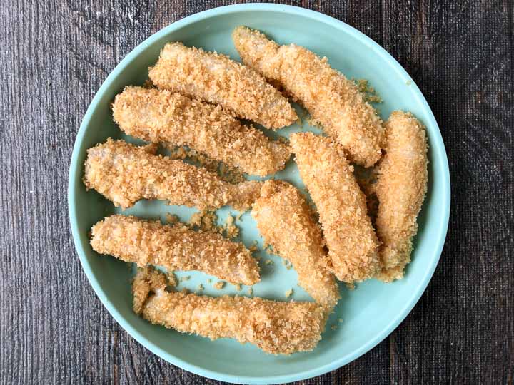 low carb fish sticks that are breaded and ready to be air fried on a blue plate