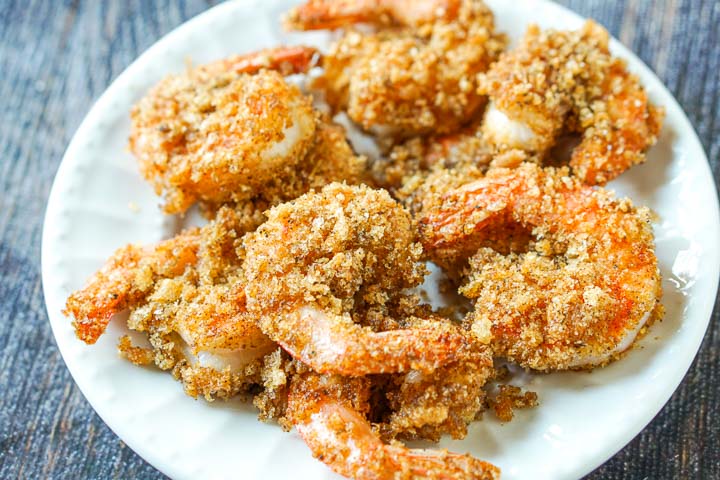 white plate with a bunch of low carb fried shrimp using pork rinds