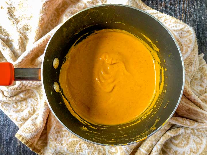 pan of low carb creamy curry carrot soup on a beige tea towel l