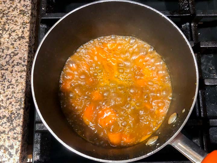 pot on stove with boiling carrots in the curry broth