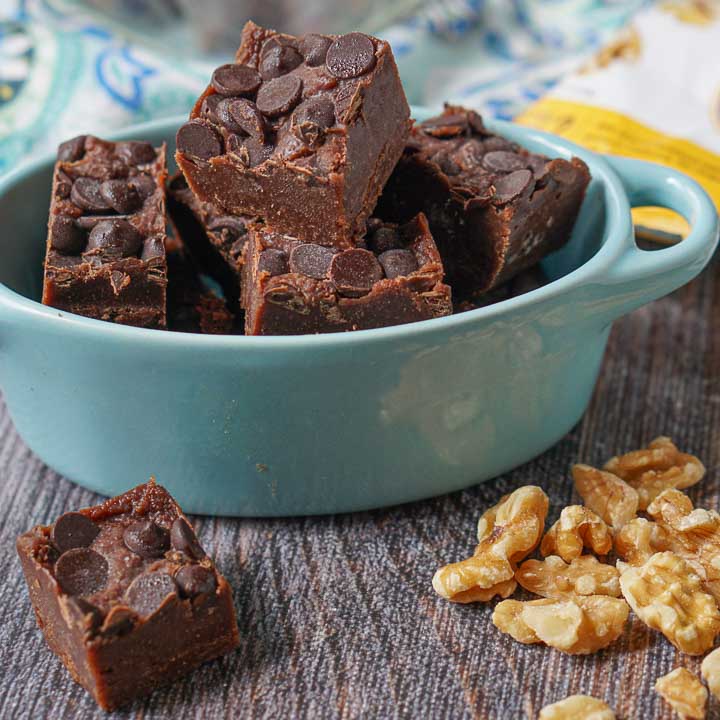 blue bowl with double chocolate keto fudge and scattered raw walnuts