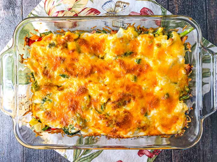 baking dish with low carb creamy vegetable & ham casserole on a floral tea towel