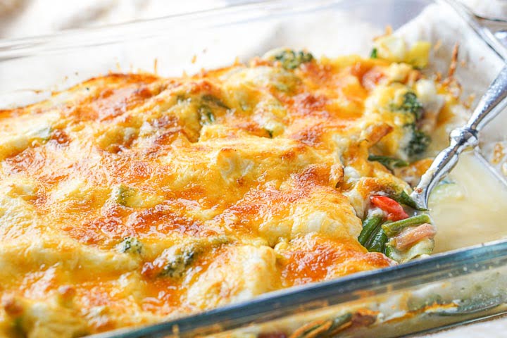baking dish with low carb creamy vegetable & ham casserole and a spoon
