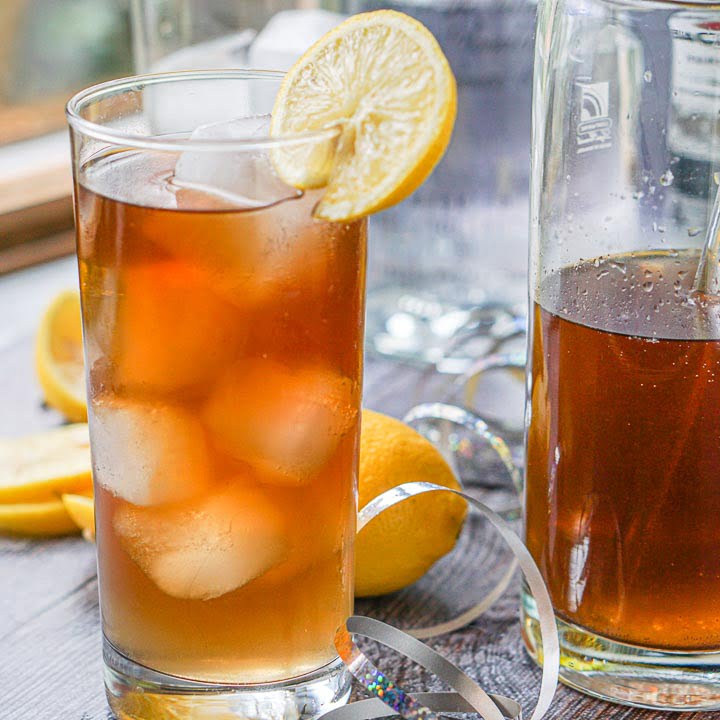 tall glass with ice and keto Long Island ice tea and some lemons in the background