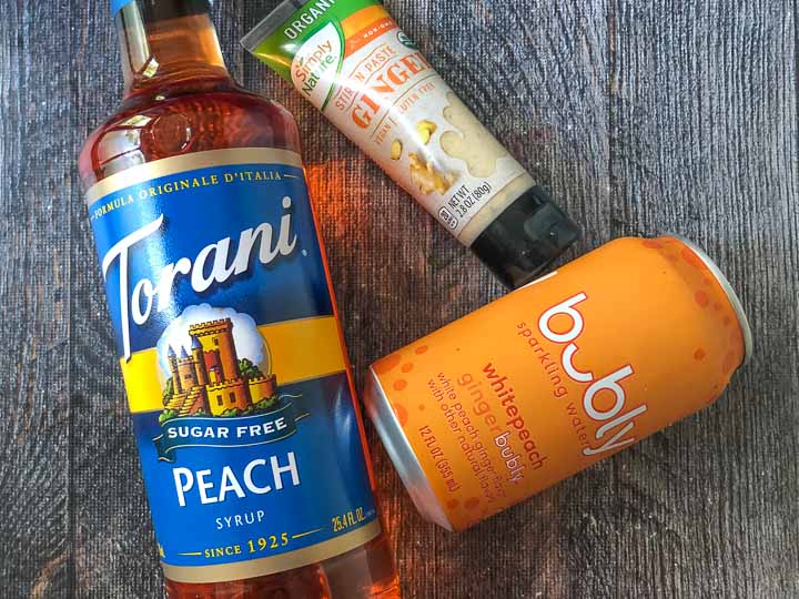 ingredients for ginger peach mule drink: Torani sugar free peach syrup, ginger paste, and Bubly ginger peach seltzer water