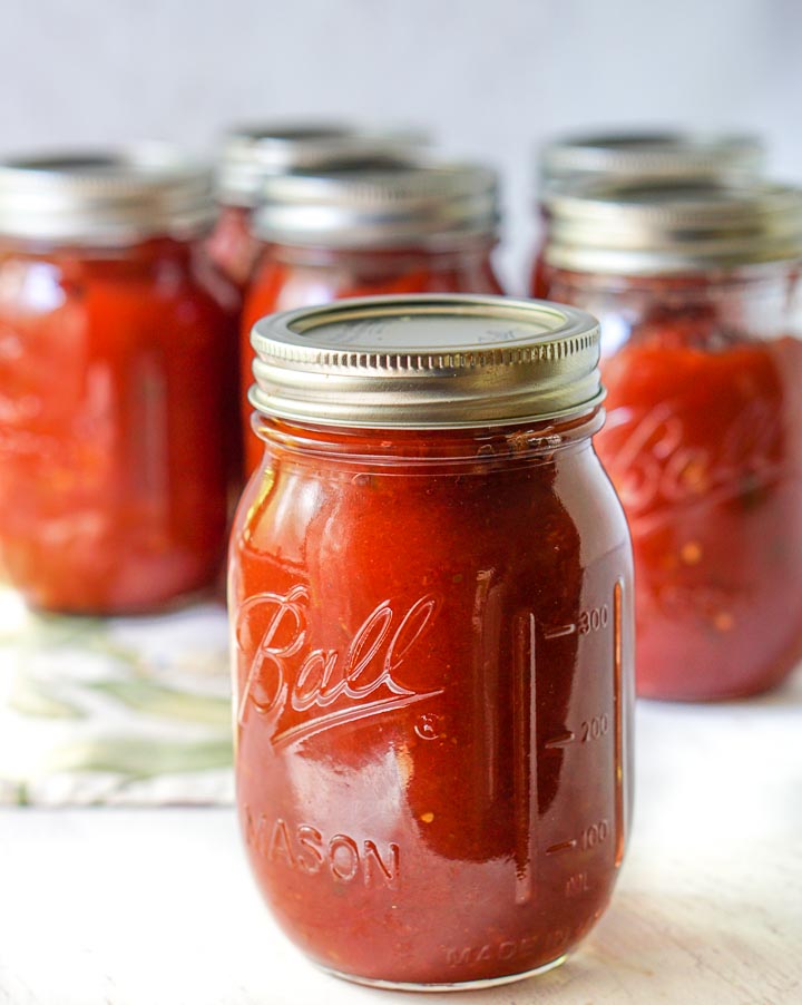 closeup of a mason jar filled with slow cooker low carb salsa and more jars in the background