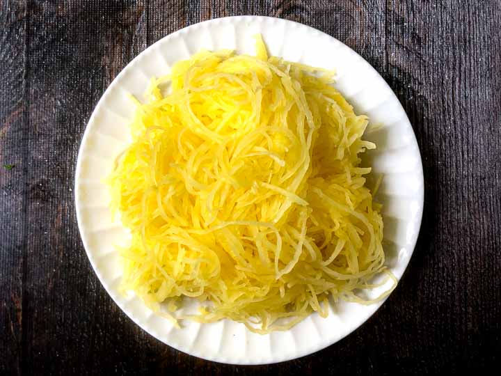 white plate with cooked spaghetti squash 
