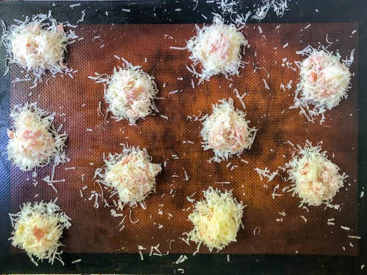 tray with silicone mat and grated cheese with ham bits ready to bake