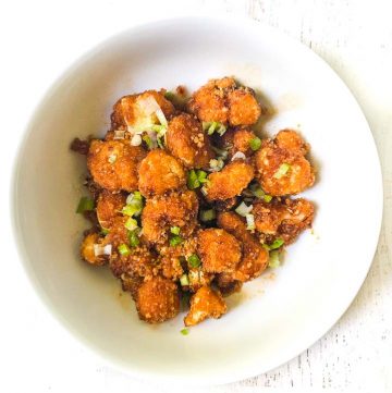 white bowl with Mongolian fried cauliflower with green onions on top