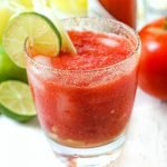 glass with keto Bloody Mary with fresh tomatoes, limes and celery and text overlay