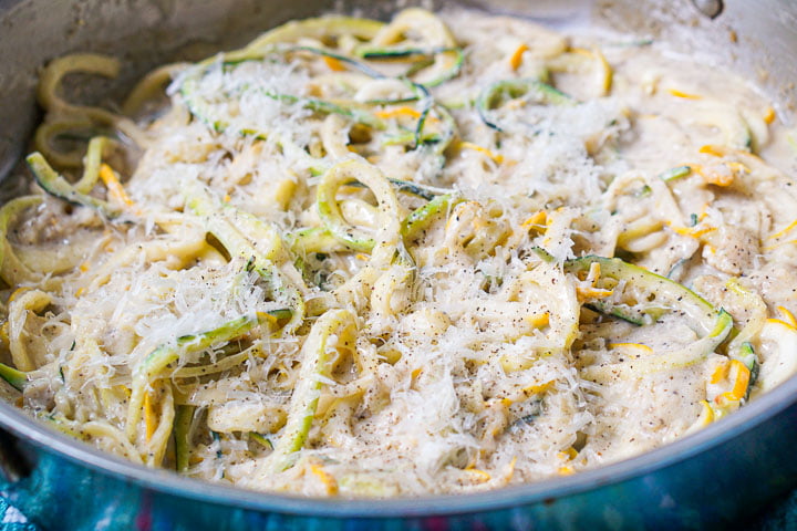 closeup of a pan of keto zucchini noodles with grated fresh parmesan cheese on top