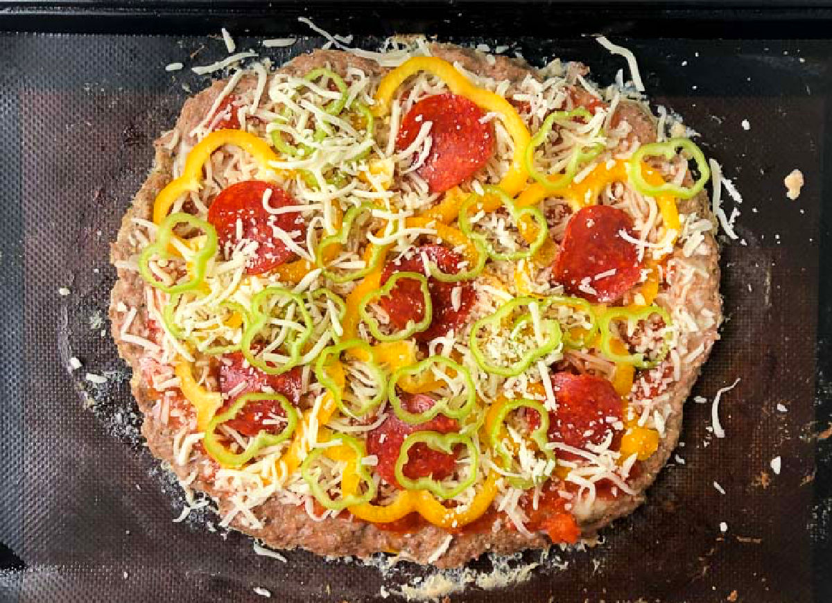 baking sheet with raw pizza with toppings ready to bake