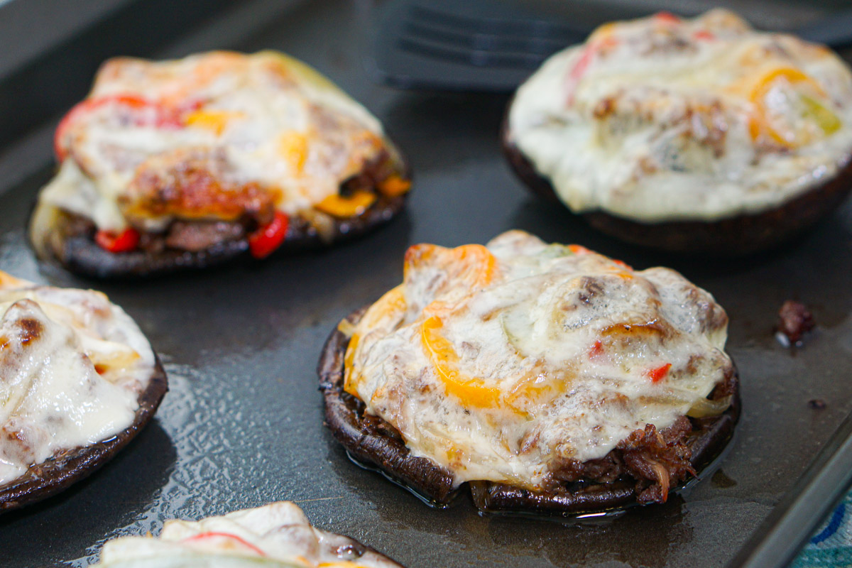 closeup of cheesesteak mushroom caps on baking tray