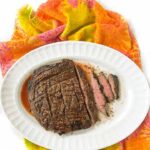 white platter and plate with keto flank steak and roasted veggies with text overlay