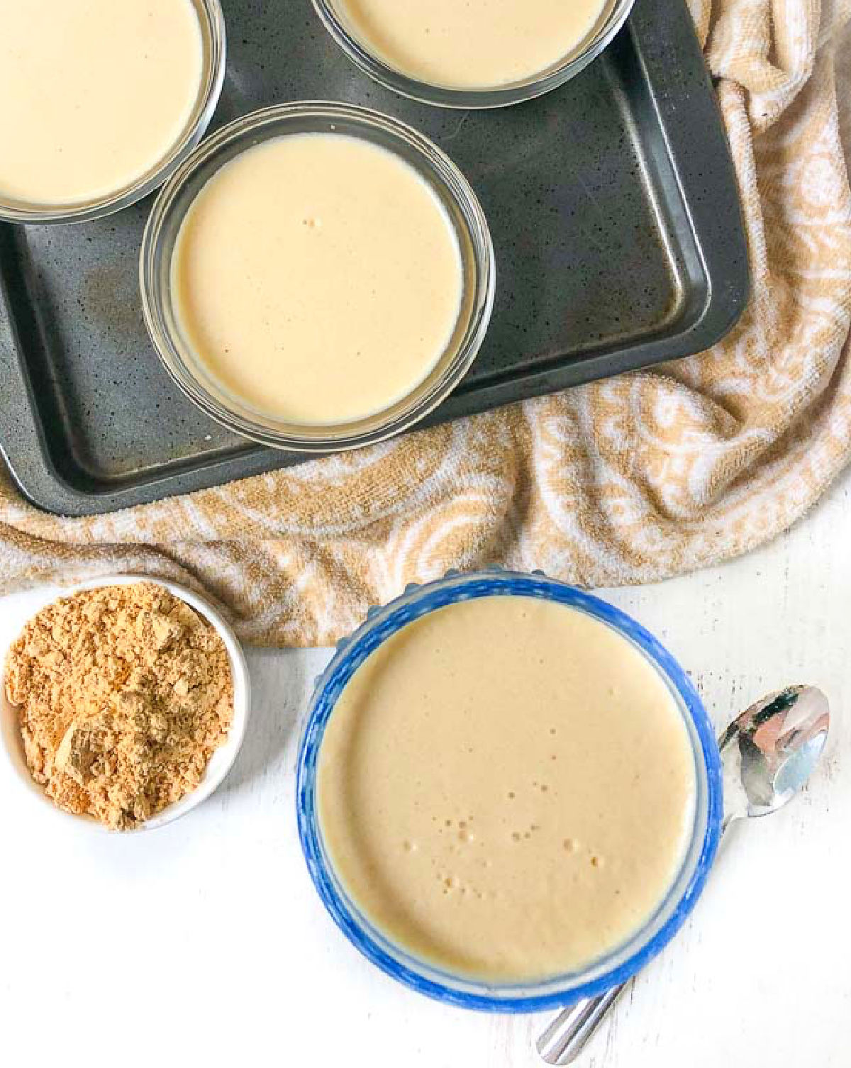 Aerial view of a few dishes with banana protein pudding and a bowl of  protein powder.