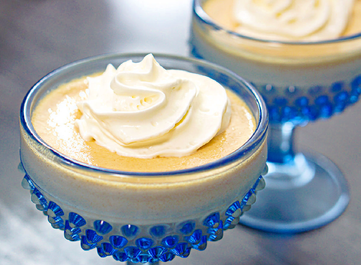 Closeup of 2 blue dessert dishes with the keto pudding with whipped cream.