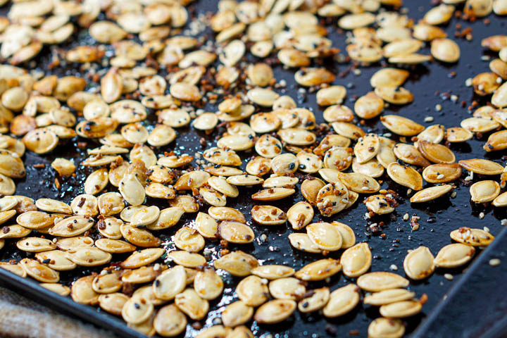 closeup of black cookie sheet with the roasted keto pumpkin seeds