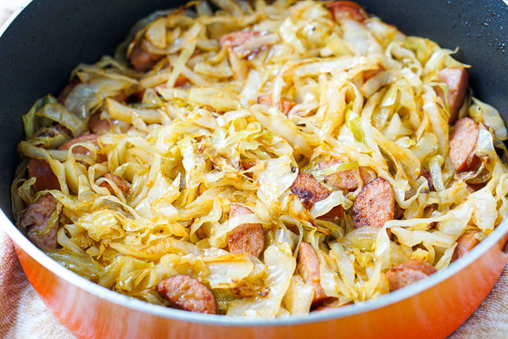 closeup of orange pan with kielbasa and cabbage noodles