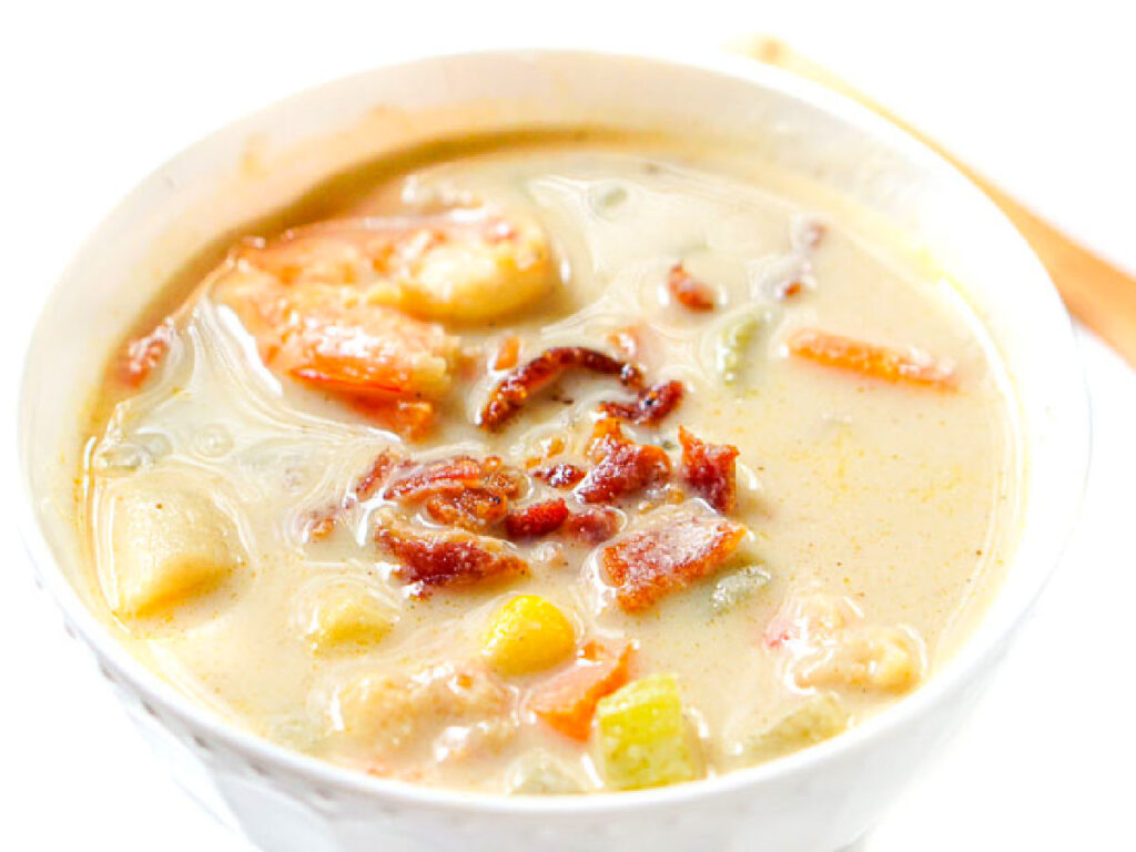 Closeup of a white bowl with the finished chowder recipe with bacon on top.