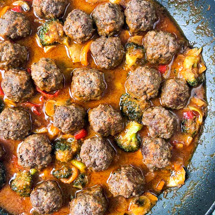 closeup of a skillet with Thai curry meatballs and veggies
