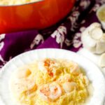 white plate and skillet with keto spaghetti squash alfredo with seafood and text overlay