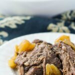closeup of a white bow and plate with keto Italian beef roast in the slow cooker with text