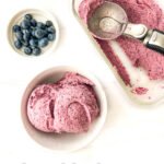 a white bowl and glass dish with keto blueberry ice cream, blueberries and text