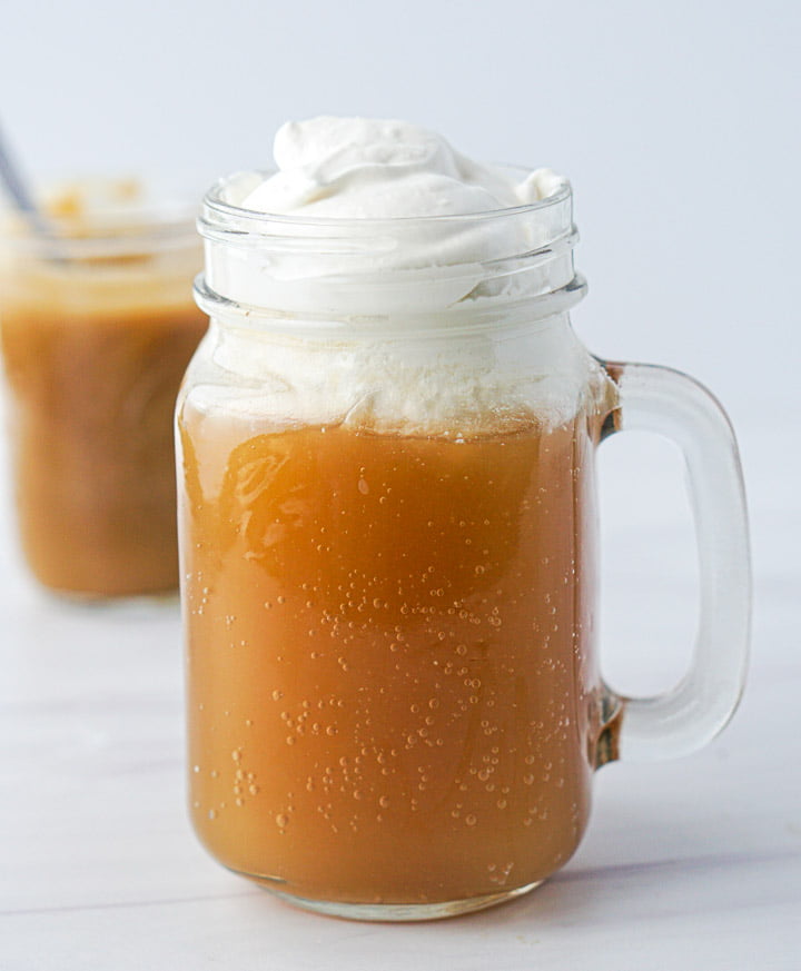 a glass mug with sugar free butterbeer and whipped topping 