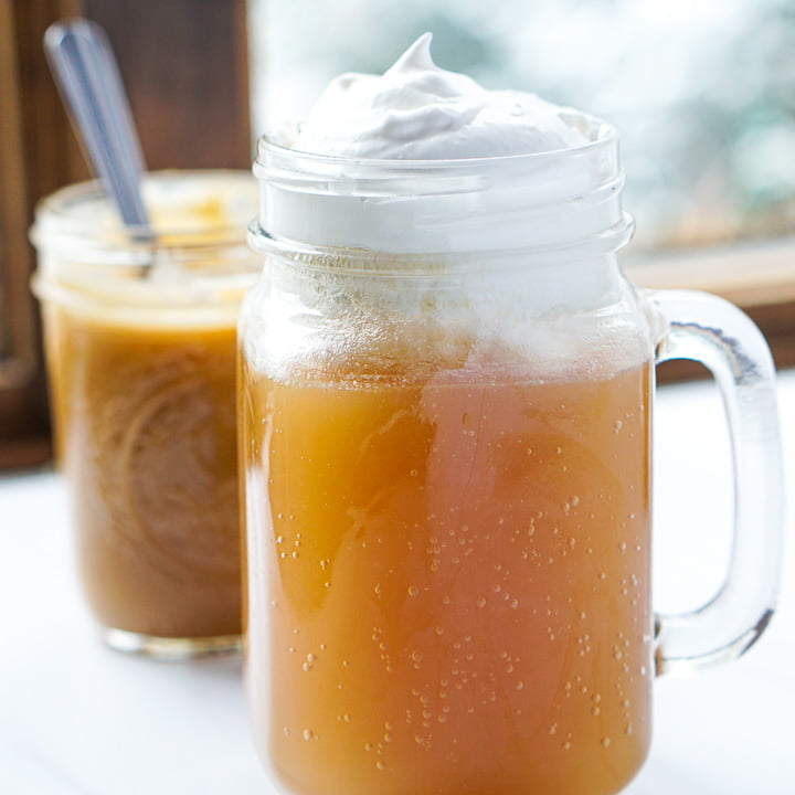 glass bug with keto butterbeer and a jar of butterscotch sauce in the background