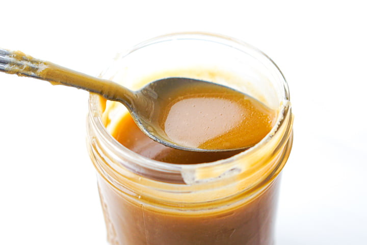 a closeup of a spoon full of butterscotch syrup 