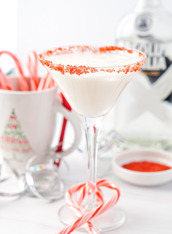 glass with peppermint martini with candy canes around the stem