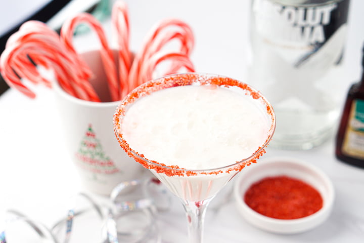 closeup of a candy cane martini with red salt around the rim